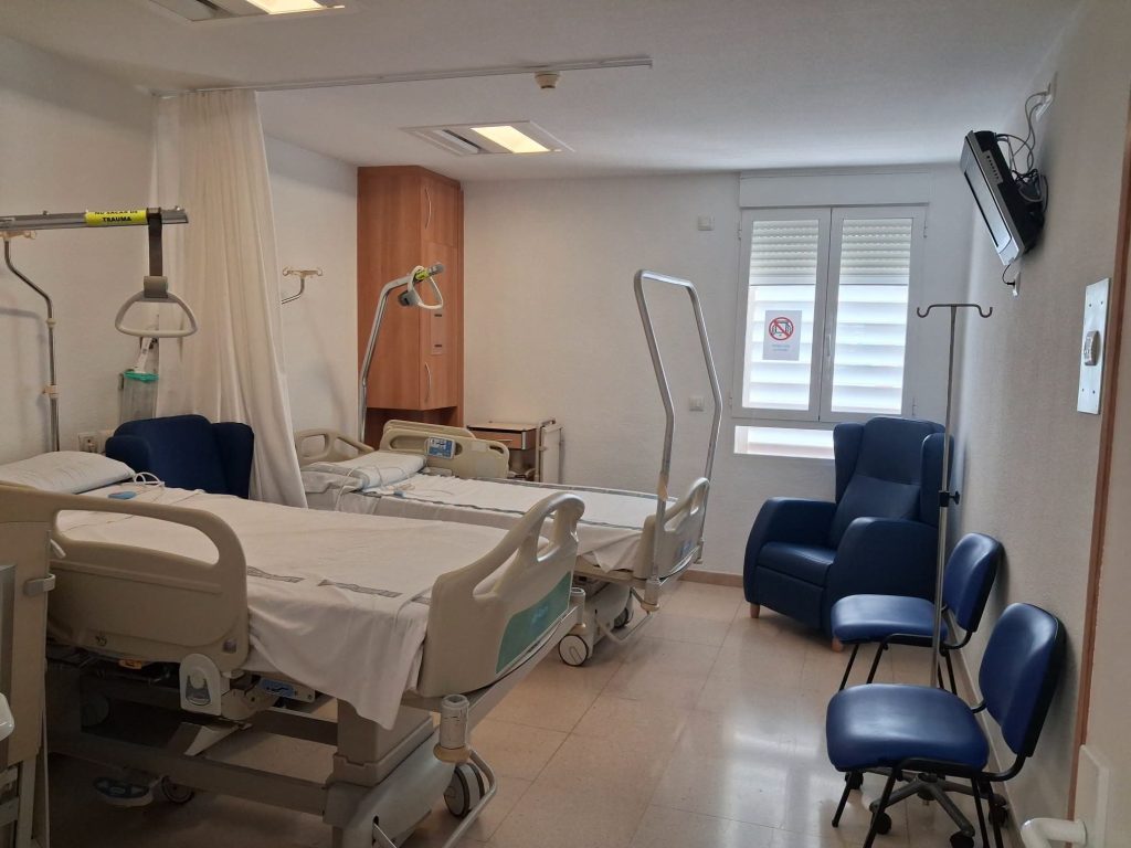 El Hospital Marina Baixa reabre la planta de Traumatología tras una inversión de 39.000 euros El Hospital Universitario Marina Baixa ha culminado este miércoles la reapertura total de su planta de hospitalización de Traumatología. La entrada en servicio de las instalaciones se produce tras dos meses de obras de acondicionamiento y una inversión pública de 38.913,60 euros destinada a modernizar los espacios comunitarios y las habitaciones del área. La recuperación del servicio se ha ejecutado de manera escalonada para minimizar el impacto en la actividad asistencial. Tras una primera fase activada el pasado 5 de septiembre con la puesta en marcha de 10 unidades, el centro sanitario vuelve a disponer de la totalidad de sus 34 camas operativas. Mejoras en el confort y el control asistencial Los trabajos de remodelación han abarcado tanto las zonas de trabajo de los profesionales como los espacios de ingreso de los pacientes: Zonas comunes y de enfermería: Se ha renovado íntegramente el mostrador del control de Enfermería, se ha instalado un nuevo sistema de iluminación y se han cambiado los techos de escayola. Mantenimiento general: Pintado completo de paredes y puertas en toda la planta. Habitaciones y equipamiento: Instalación de nuevos sillones para los ingresados, sustitución de rieles y cortinas separadoras de espacio y renovación de la fontanería higiénica, incluyendo un nuevo fregadero para cuñas y la actualización de los aseos. Con la finalización de estos trabajos, el centro sanitario ubicado en La Vila Joiosa optimiza la calidad de la atención hospitalaria y recupera su capacidad operativa del área quirúrgica y traumatológica.
